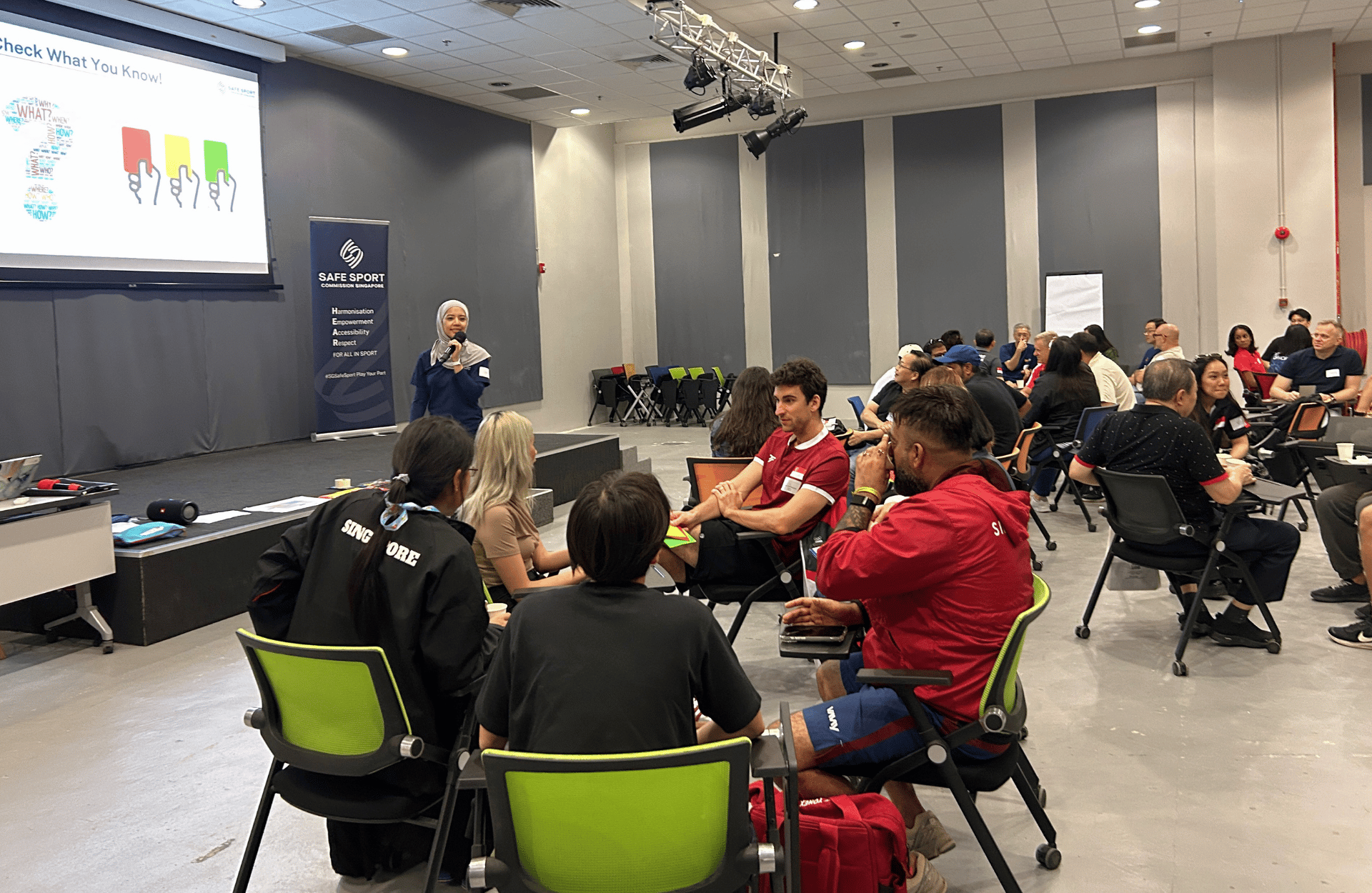 A group workshop in a conference room with seating in small circles.