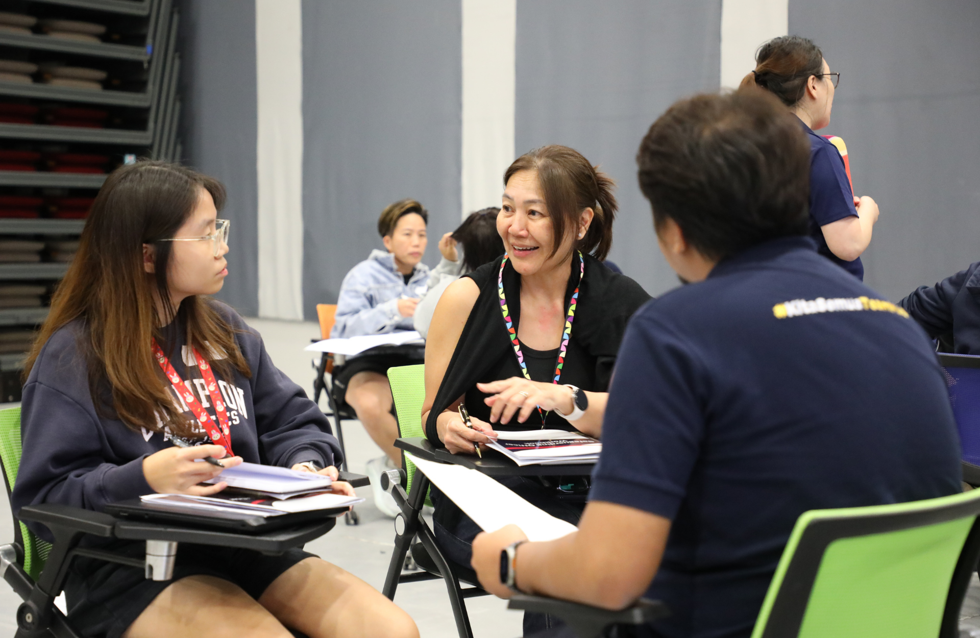 Two women in discussion while a man listens in